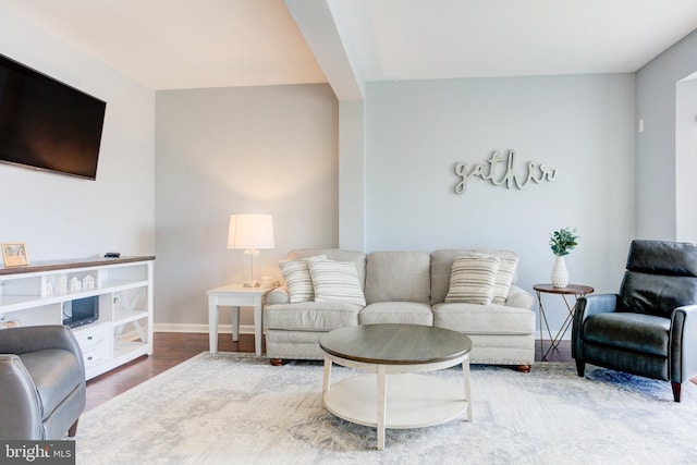 living area with baseboards and wood finished floors