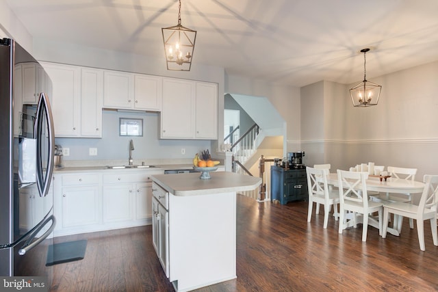 kitchen featuring light countertops, freestanding refrigerator, decorative light fixtures, and white cabinetry