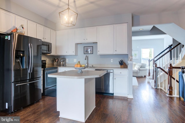 kitchen featuring stainless steel appliances, light countertops, hanging light fixtures, and white cabinetry