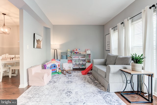 rec room with a chandelier, wood finished floors, and baseboards