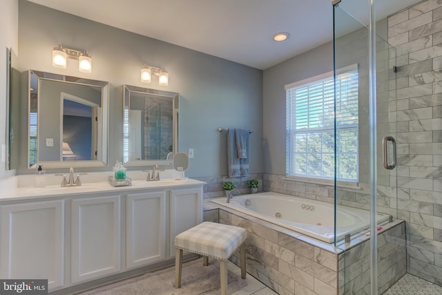 bathroom featuring a whirlpool tub, a sink, and a shower stall