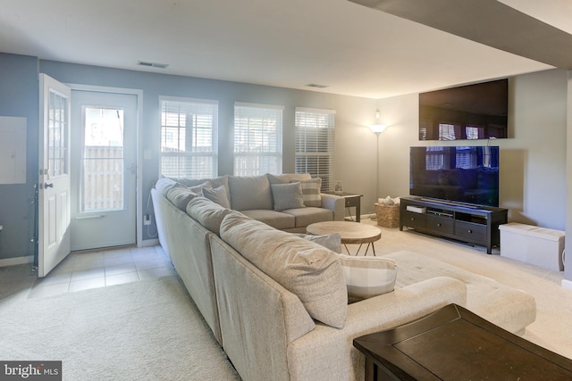 living room with light tile patterned floors, baseboards, visible vents, and light colored carpet