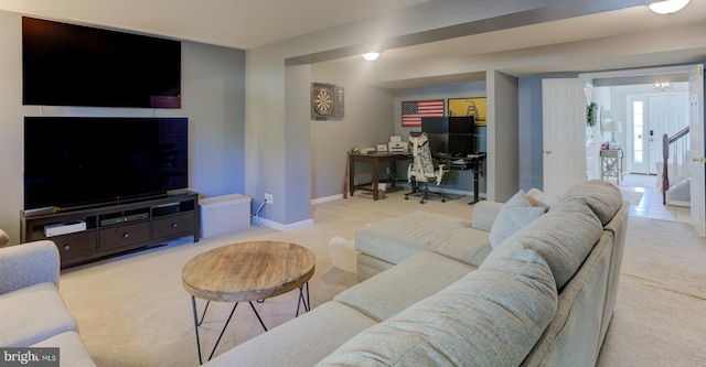 living room featuring stairway, light colored carpet, and baseboards