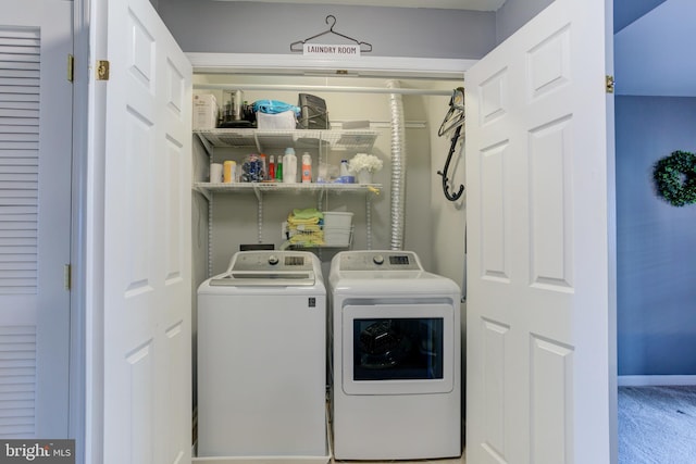 laundry area with laundry area, washing machine and dryer, and baseboards