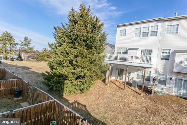 back of property with a fenced backyard and cooling unit