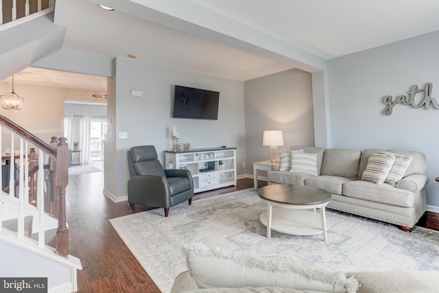 living room with dark wood-style floors, a chandelier, stairway, and baseboards