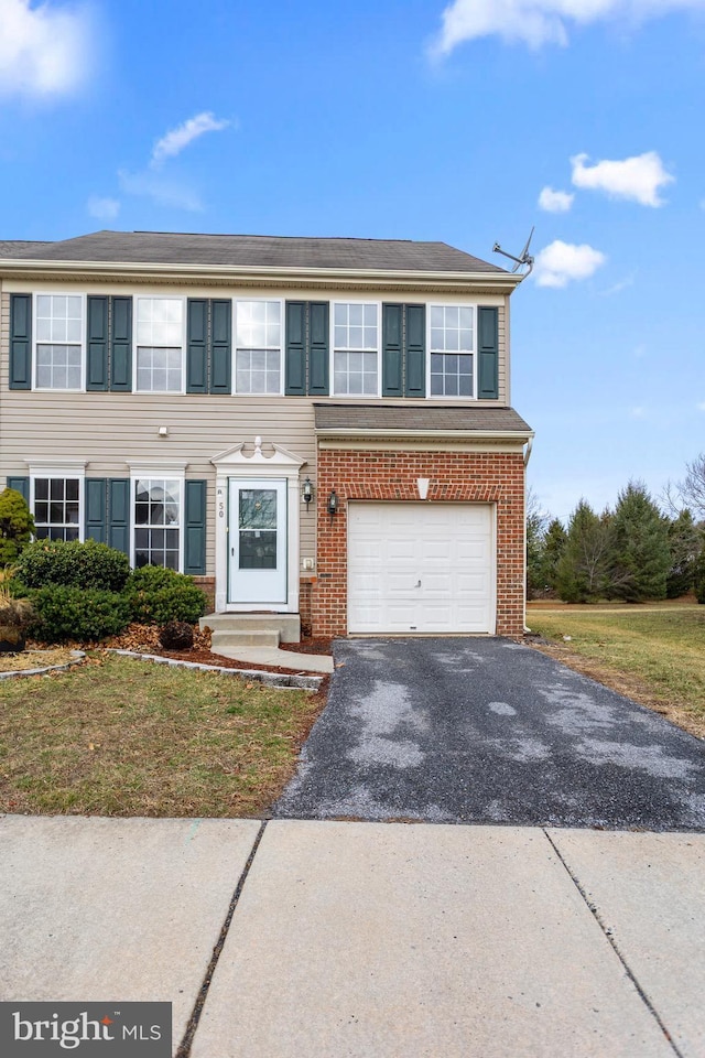 view of front of home featuring a garage, aphalt driveway, and brick siding