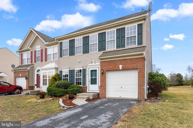 view of front of property with a garage, brick siding, a front yard, and aphalt driveway