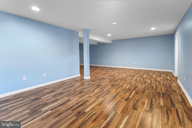 finished below grade area featuring dark wood-style flooring, recessed lighting, and baseboards