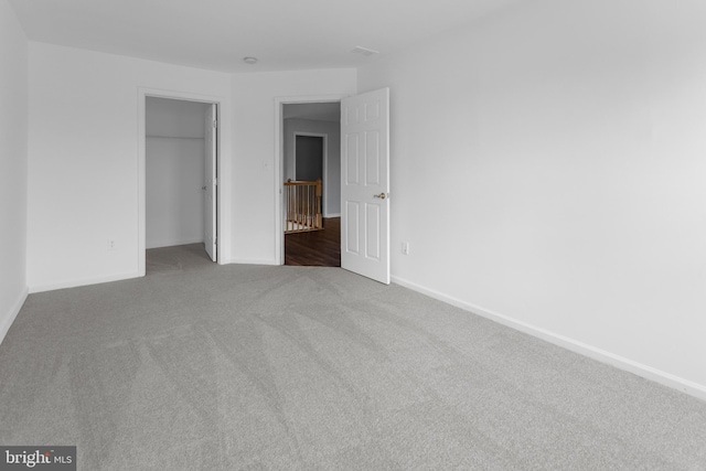 unfurnished bedroom featuring carpet floors, baseboards, and a closet