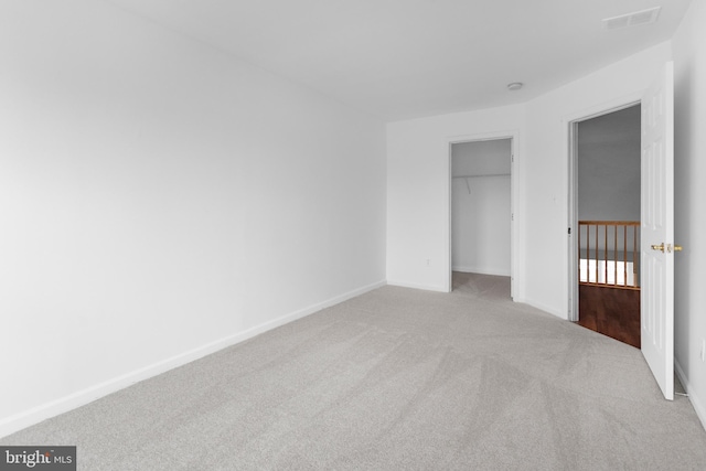 unfurnished bedroom featuring carpet, a closet, visible vents, and baseboards