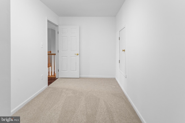 unfurnished room with carpet and baseboards