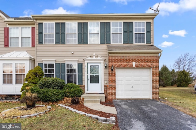 view of front of home with a garage, driveway, and brick siding