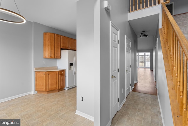 hallway featuring baseboards and stairs