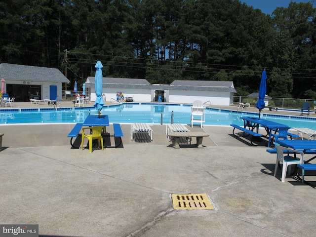 community pool with fence and a patio