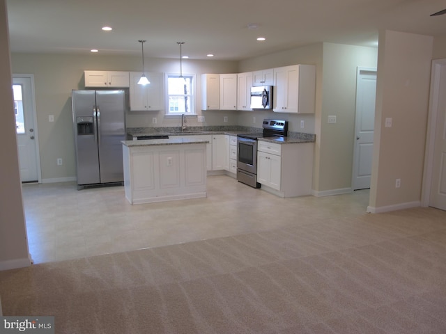 kitchen featuring white cabinets, light carpet, appliances with stainless steel finishes, and pendant lighting