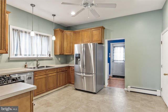 kitchen featuring a sink, light countertops, baseboard heating, brown cabinetry, and stainless steel fridge