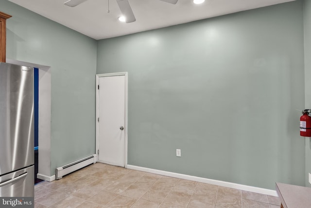 empty room featuring a baseboard heating unit, a ceiling fan, and baseboards