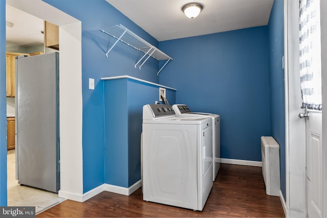 washroom with laundry area, washing machine and dryer, baseboards, and wood finished floors