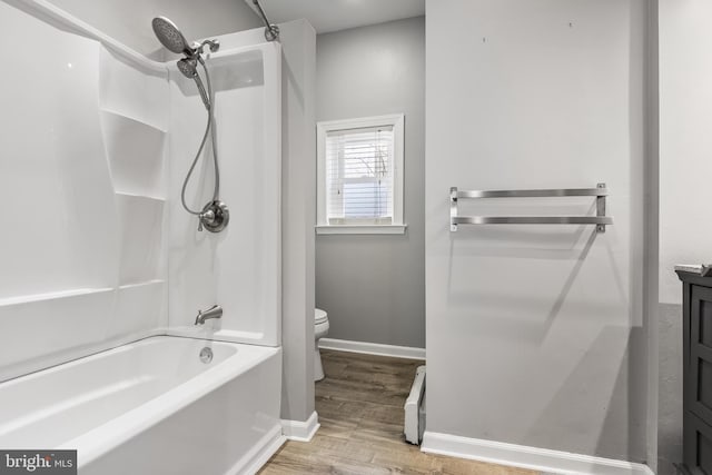 bathroom with toilet, wood finished floors, vanity, baseboards, and tub / shower combination