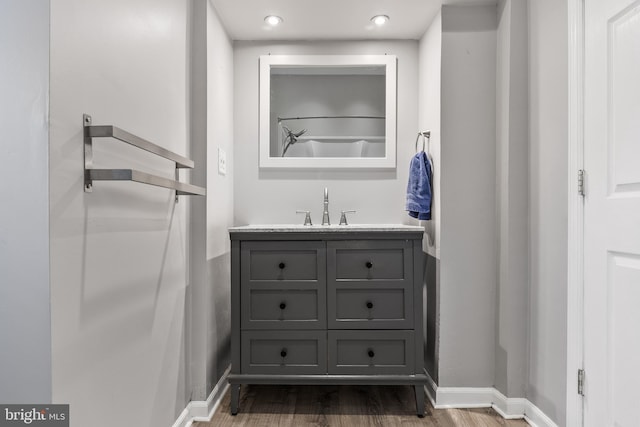 bathroom featuring baseboards, wood finished floors, and vanity