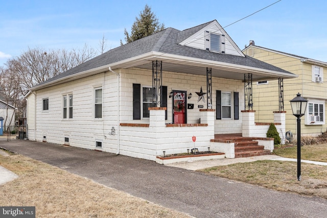 bungalow-style home featuring crawl space, a shingled roof, and a porch