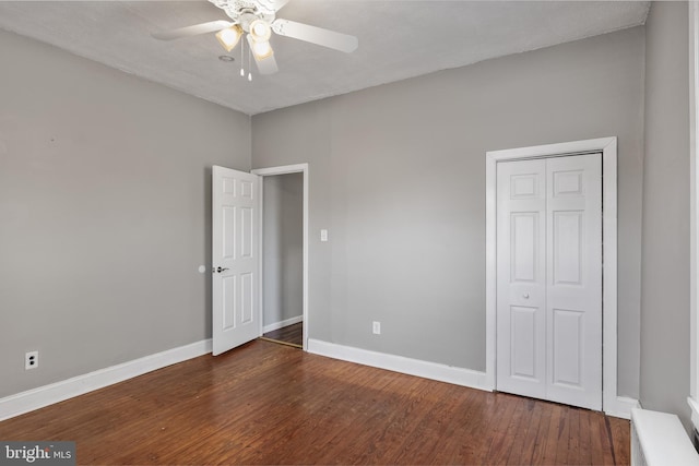 unfurnished bedroom featuring a ceiling fan, a closet, baseboards, and wood finished floors