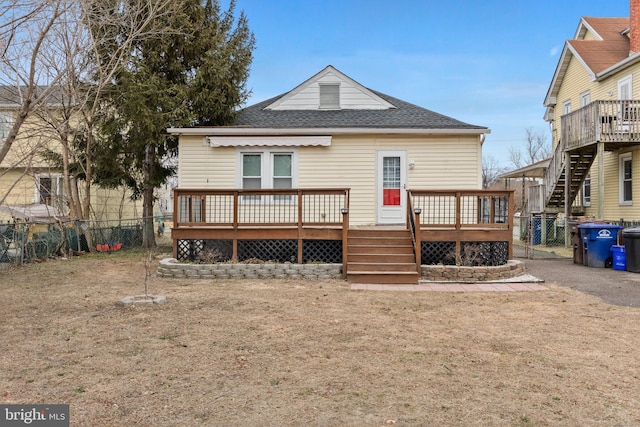 rear view of property with a shingled roof, fence, a deck, and stairs