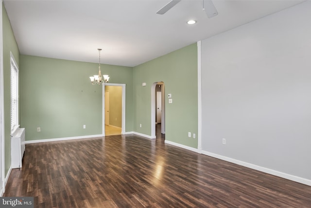 spare room with arched walkways, recessed lighting, wood finished floors, baseboards, and ceiling fan with notable chandelier