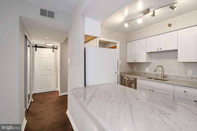 kitchen with visible vents, a sink, freestanding refrigerator, a barn door, and dishwasher