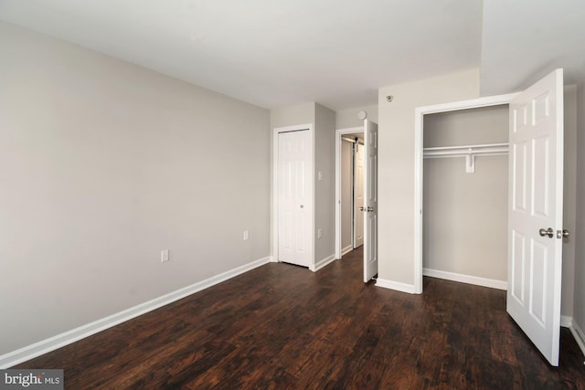 unfurnished bedroom featuring dark wood finished floors and baseboards