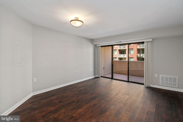 spare room featuring wood finished floors, visible vents, and baseboards