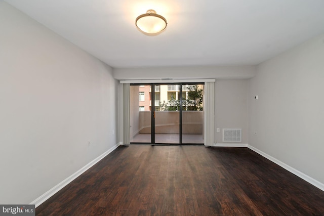 spare room with wood finished floors, baseboards, and visible vents