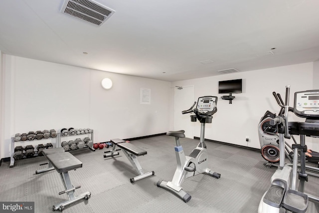 exercise room with baseboards and visible vents