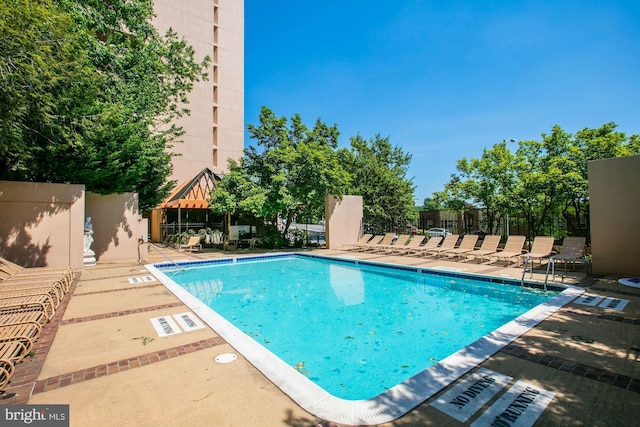 community pool featuring a patio and fence