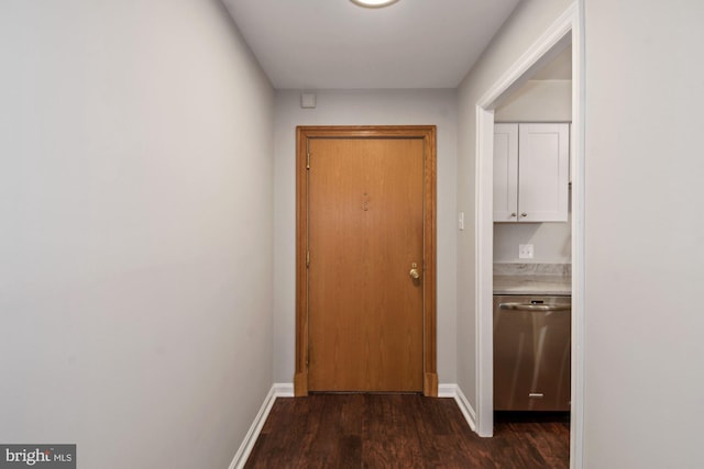 hallway featuring dark wood finished floors and baseboards