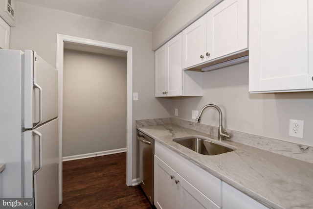 kitchen with white cabinetry, stainless steel dishwasher, freestanding refrigerator, and a sink