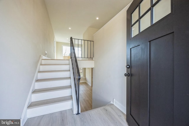 foyer with recessed lighting, stairway, baseboards, and wood finished floors