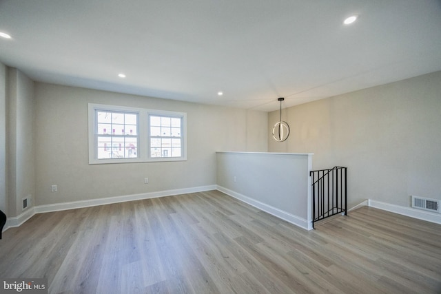 unfurnished room featuring baseboards, visible vents, wood finished floors, and recessed lighting