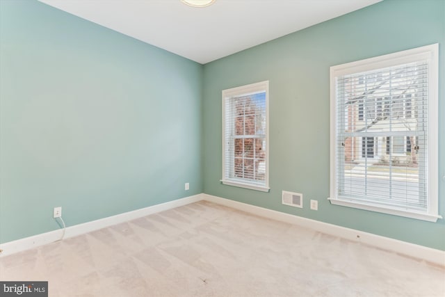 spare room featuring visible vents, baseboards, and carpet floors