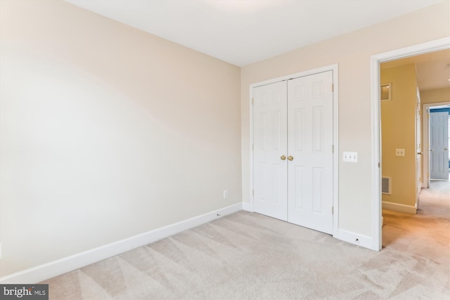 unfurnished bedroom with visible vents, carpet floors, baseboards, and a closet