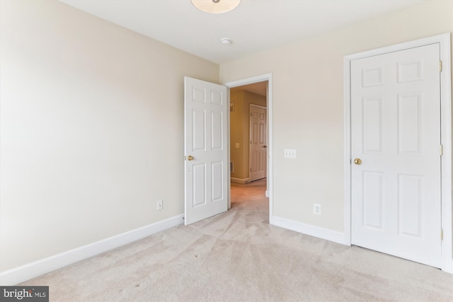 unfurnished bedroom with light carpet and baseboards