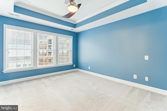 spare room featuring baseboards, visible vents, a tray ceiling, crown molding, and carpet flooring