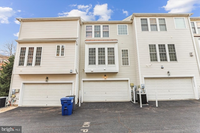 back of house with a garage and driveway