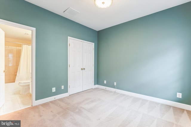 unfurnished bedroom with carpet, visible vents, a closet, and baseboards