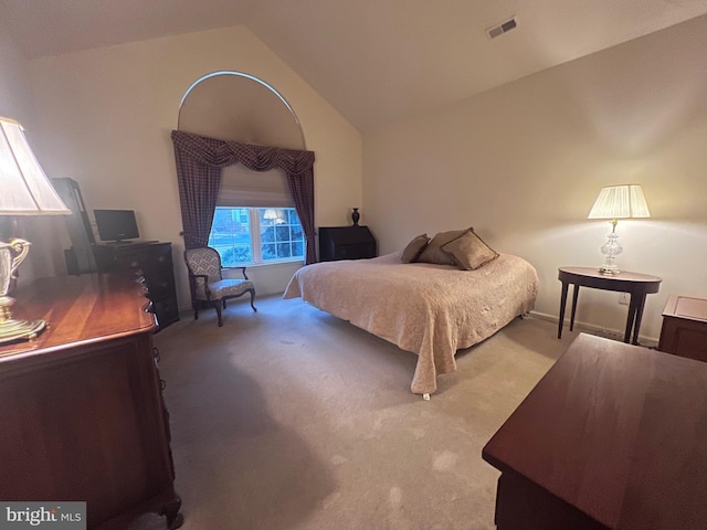 bedroom featuring vaulted ceiling and light colored carpet