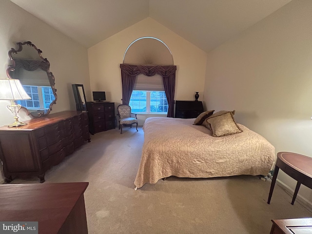 bedroom featuring light carpet and vaulted ceiling