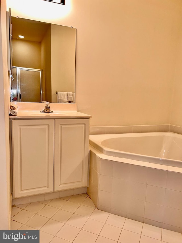 bathroom featuring a shower stall, a garden tub, vanity, and tile patterned floors