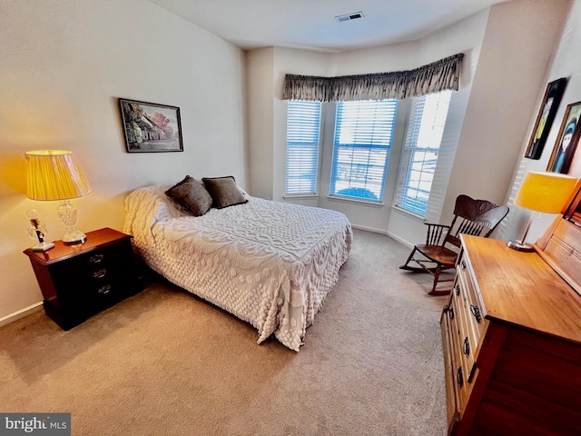 carpeted bedroom featuring baseboards and visible vents