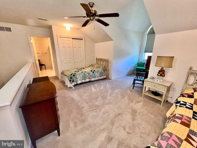 bedroom featuring lofted ceiling, ceiling fan, carpet flooring, visible vents, and a closet